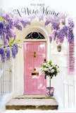 This image shows a welcoming doorway that feels at home in the quieter corners of Holborn, where pastel-painted fronts and flowering vines soften the urban pace. A pink front door, finished in a soothing, dusty blush tone, stands at the centre, its surface catching the light in soft, matte reflections that make the colour feel cosy rather than bold. Above and around it, wisteria cascades in generous drifts of lavender blossoms, their elongated clusters hanging like fragrant garlands that lend movement and romance to the otherwise simple façade. The walls are whitewashed, with just enough texture visible to suggest age and character, and a modest shutter painted in a complementary pastel adds balance to the composition. Resting on the top step is a florist's bucket arrangement that seems tailored for a housewarming or congratulations gesture in central London: a grey metal bucket overflowing with lush white and cream roses. The roses are arranged in a natural yet thoughtful style, some blooms fully open to reveal their centre while others remain in softer, rounded buds. Soft green foliage curls around and between the flowers, adding a gentle touch of contrast and enhancing the freshness of the design. A delicate pink ribbon encircles the base of the bucket, tied into a simple bow that ties together the palette of the door, the roses, and the wisteria above. Dappled sunlight filters through the hanging vines, producing quiet, irregular shadows that fall across the steps and lend depth to the scene. The overall feeling is one of calm, hope, and intimate celebration-perfect for expressing the joy of settling into a new place near Holborn, where every return to the front door becomes a small ritual of comfort and belonging.